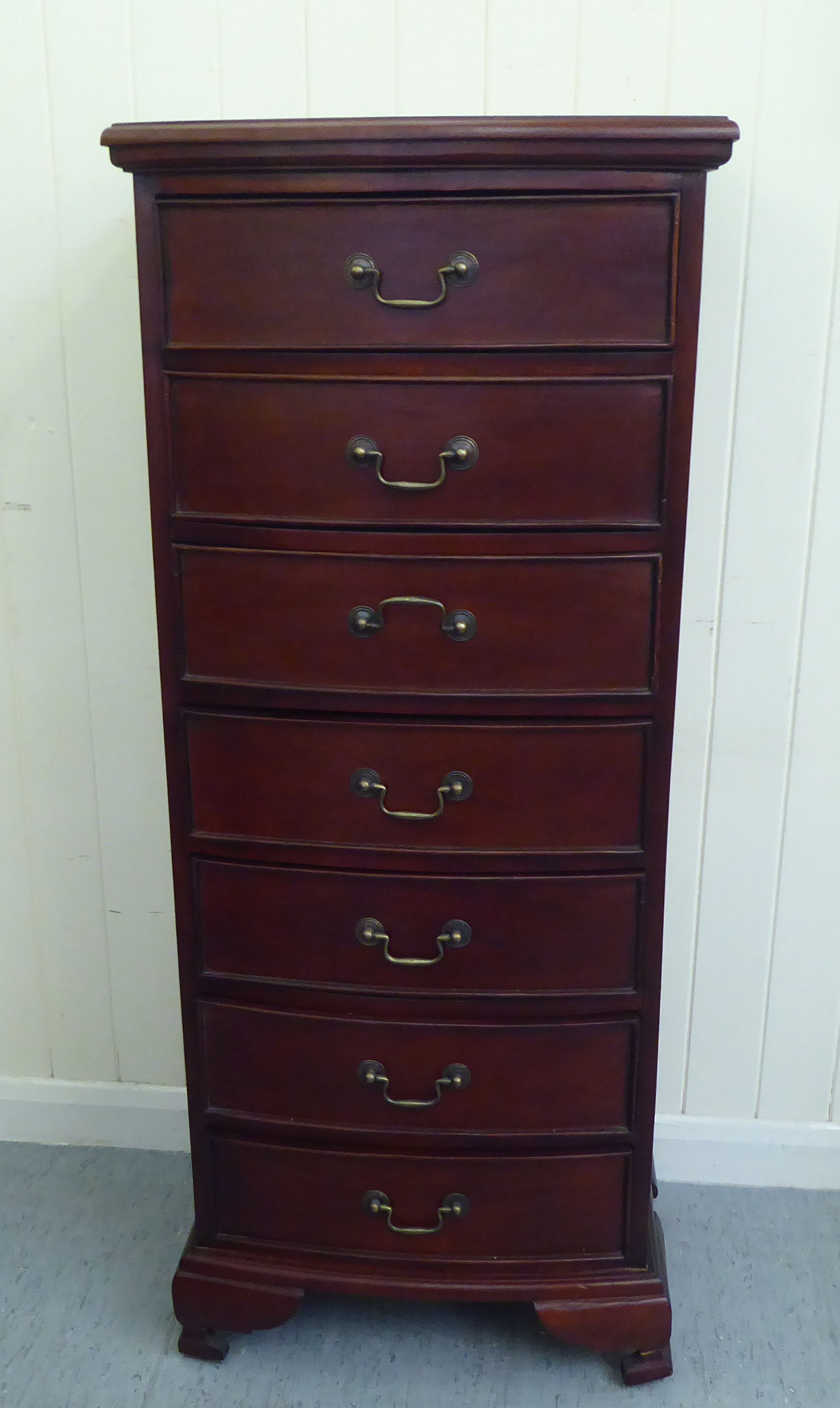 A modern mahogany bow front seven drawer tallboy, raised on bracket feet  47"h  20"w