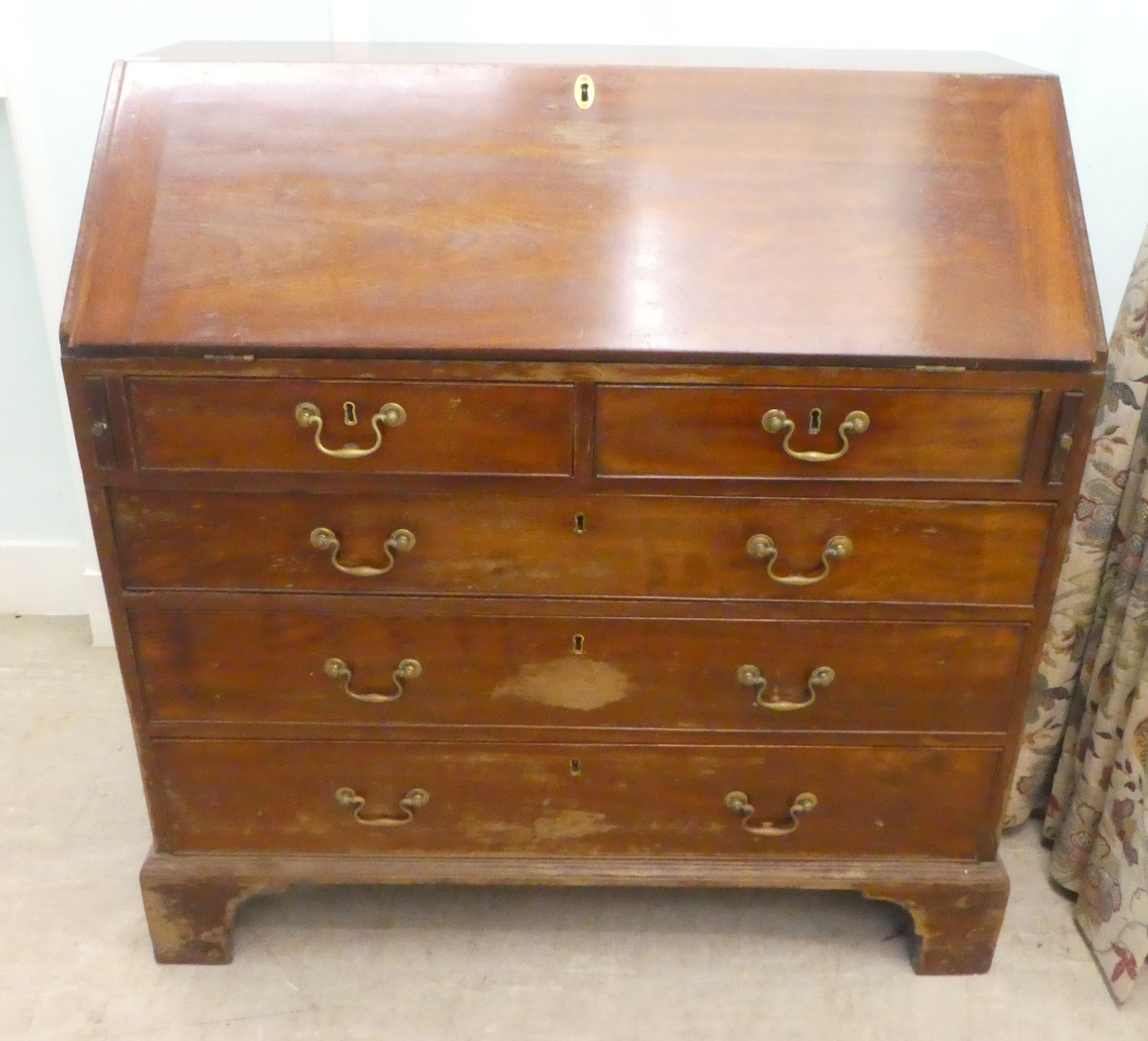 A 19thC mahogany bureau, the fall flap over two short/three graduated long drawers, raised on
