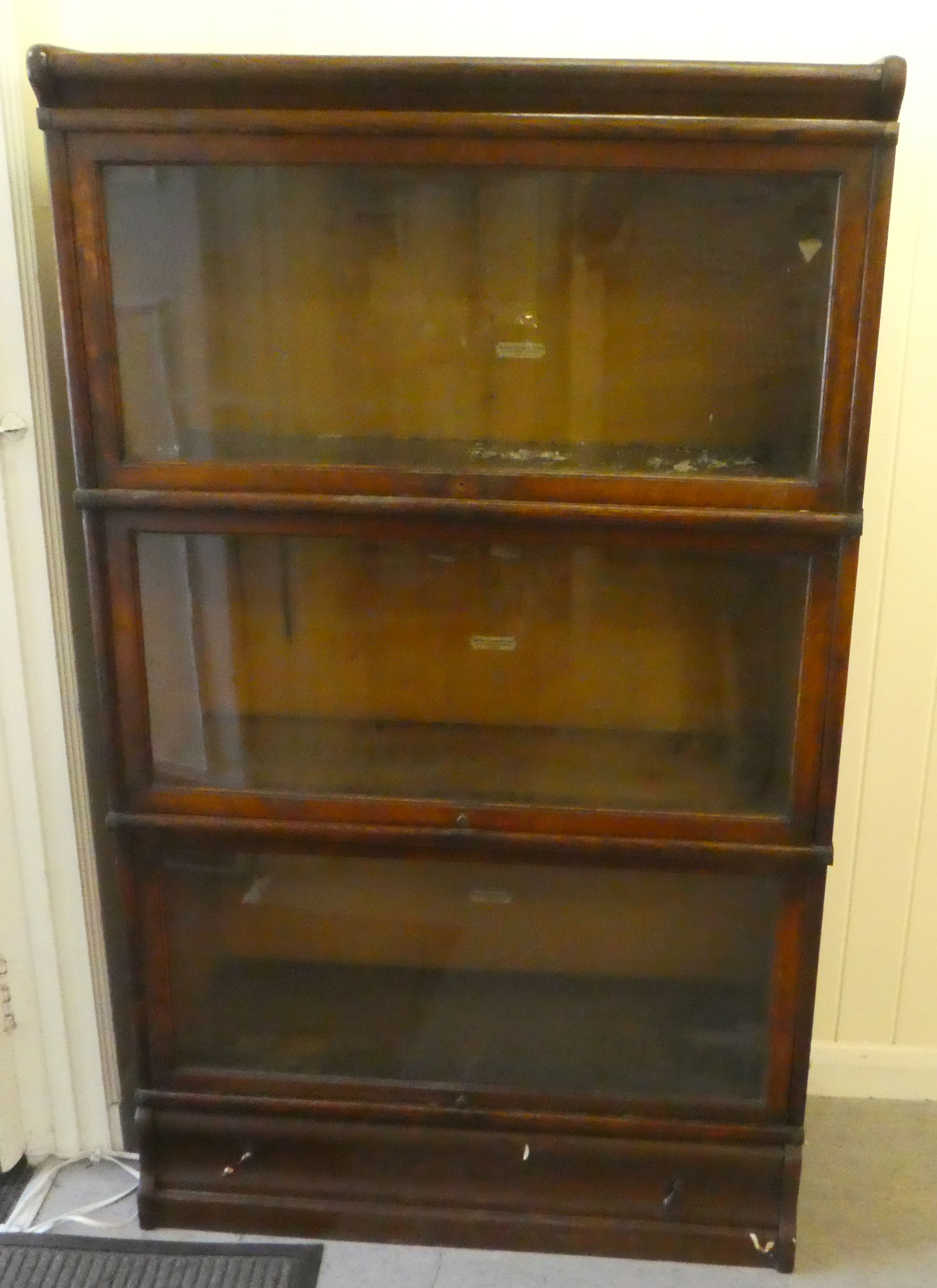 A 1920s/30s oak matched and adapted three section bookcase with lift and slide doors and a base