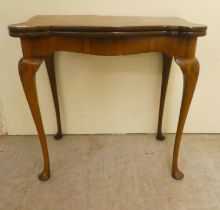 A mid 20thC Queen Anne style quarter walnut veneered card table, the hinged top over slender legs