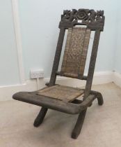 An early/mid 20thC Burmese carved hardwood and wicker panelled folding veranda chair