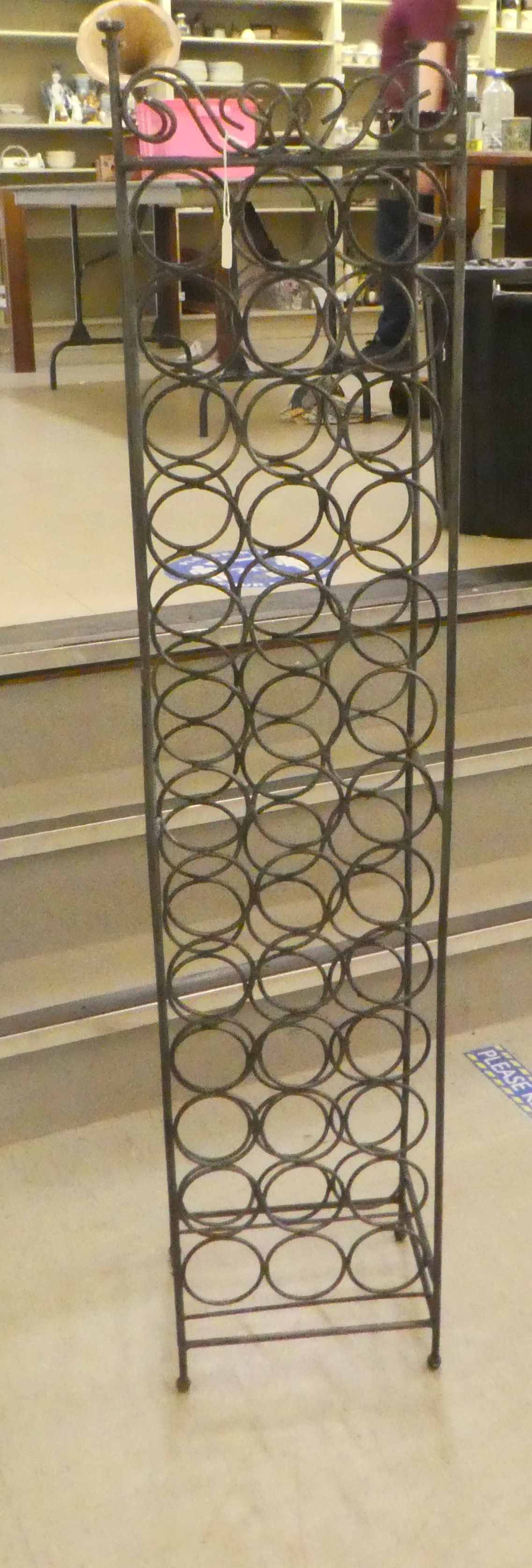 A wrought iron freestanding wine rack, accommodating 39 bottles  59"h  13"w