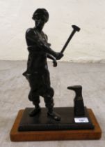 A patinated bronze model  'Ironmonger' on a wooden plinth  14"h