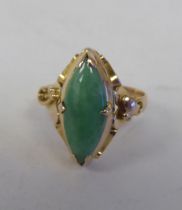 A yellow metal ring, set with a cabochon jade  stamped 14k