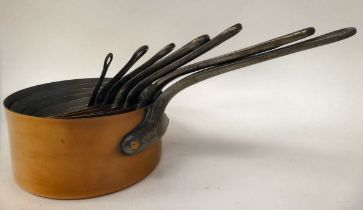 A graduated set of six early 20thC copper saucepans, on cast iron handles