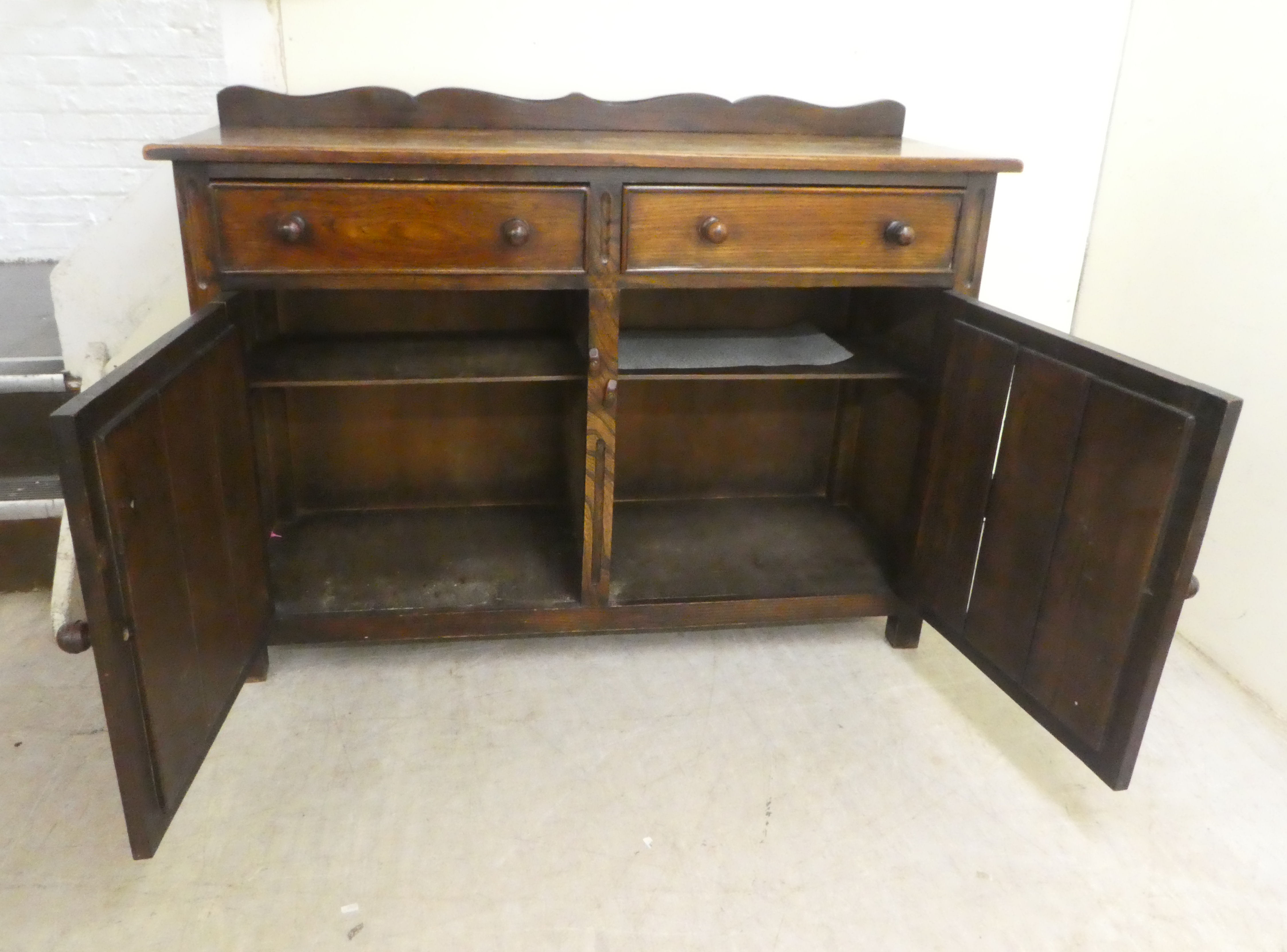 A 20thC Old English style oak dresser with two frieze drawers, over two panelled doors, raised on - Image 3 of 4