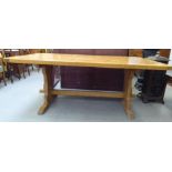 A modern waxed pine farmhouse style refectory table, raised on planked ends, united by a