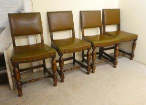 A set of four 20thC Old English style oak and stained beech framed dining chairs with stud
