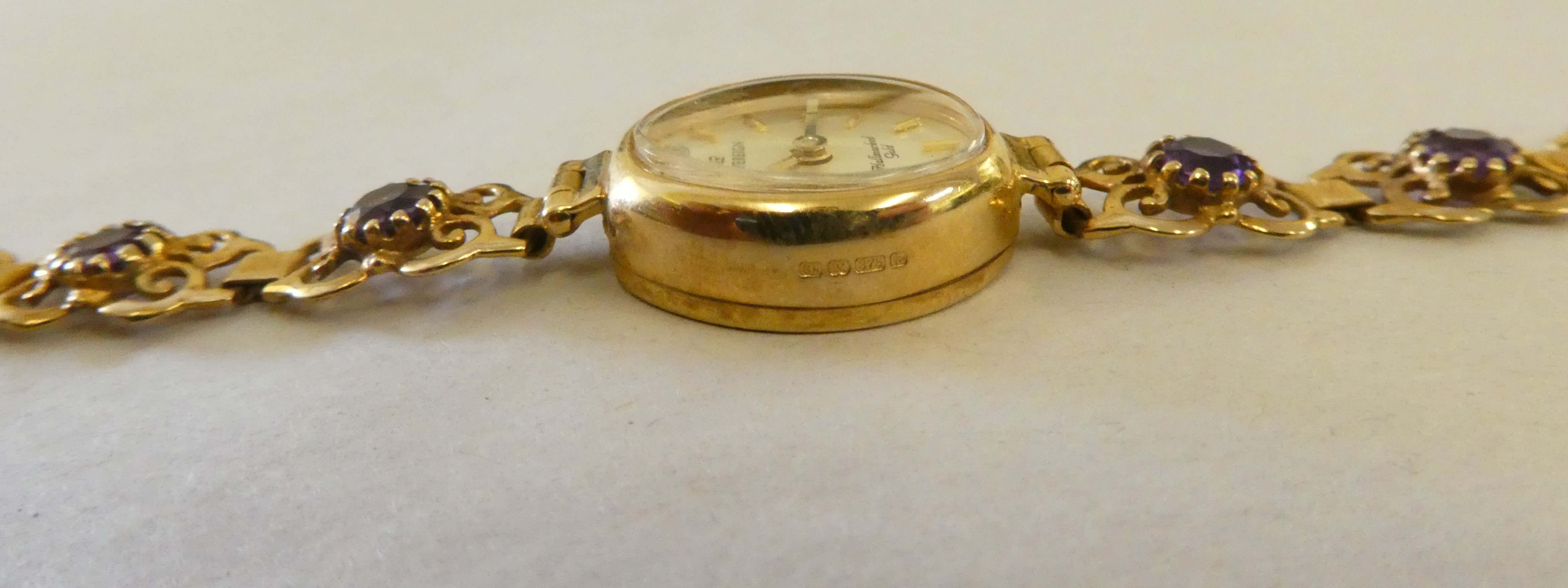 A lady's Hallmark 9ct gold cased bracelet wristwatch, claw set with purple stones, faced by a - Image 6 of 7