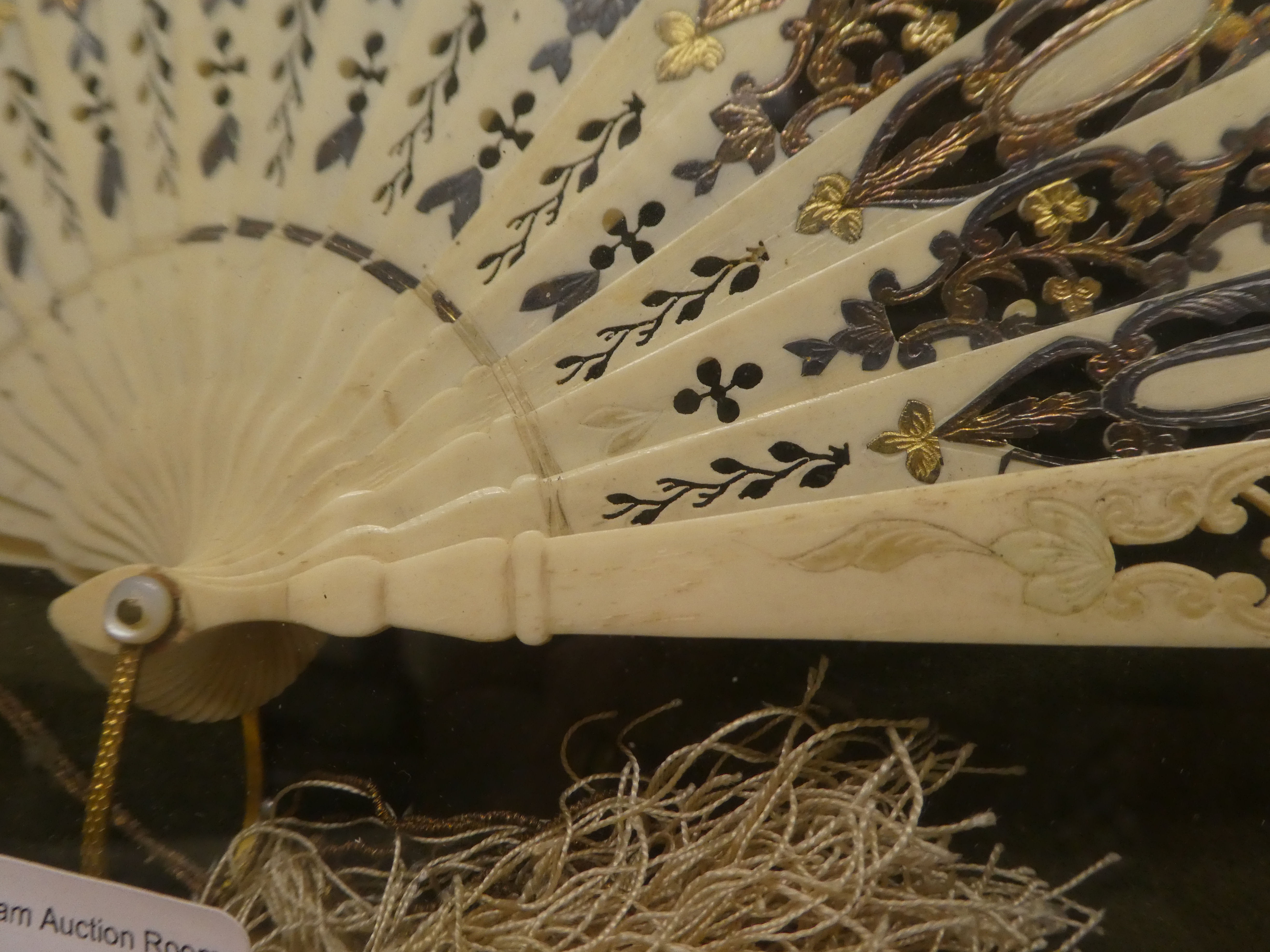 An early 20thC fan, decorated with figures in conversation, on bone spines, in a glazed box frame - Image 3 of 4