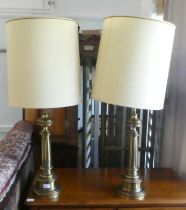 A pair of modern lacquered brass table lamps, fashioned as tapered, fluted columns, on circular