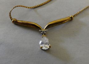 A 9ct gold fine flexible link necklet with a wishbone pendant, claw set with a white coloured stone