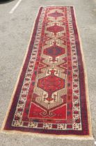 A Persian runner, decorated with repeating designs, on a multi-coloured ground  40" x 164"