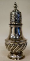 An Edwardian silver caster of pedestal vase design with demi-reeded and extravagantly cast and