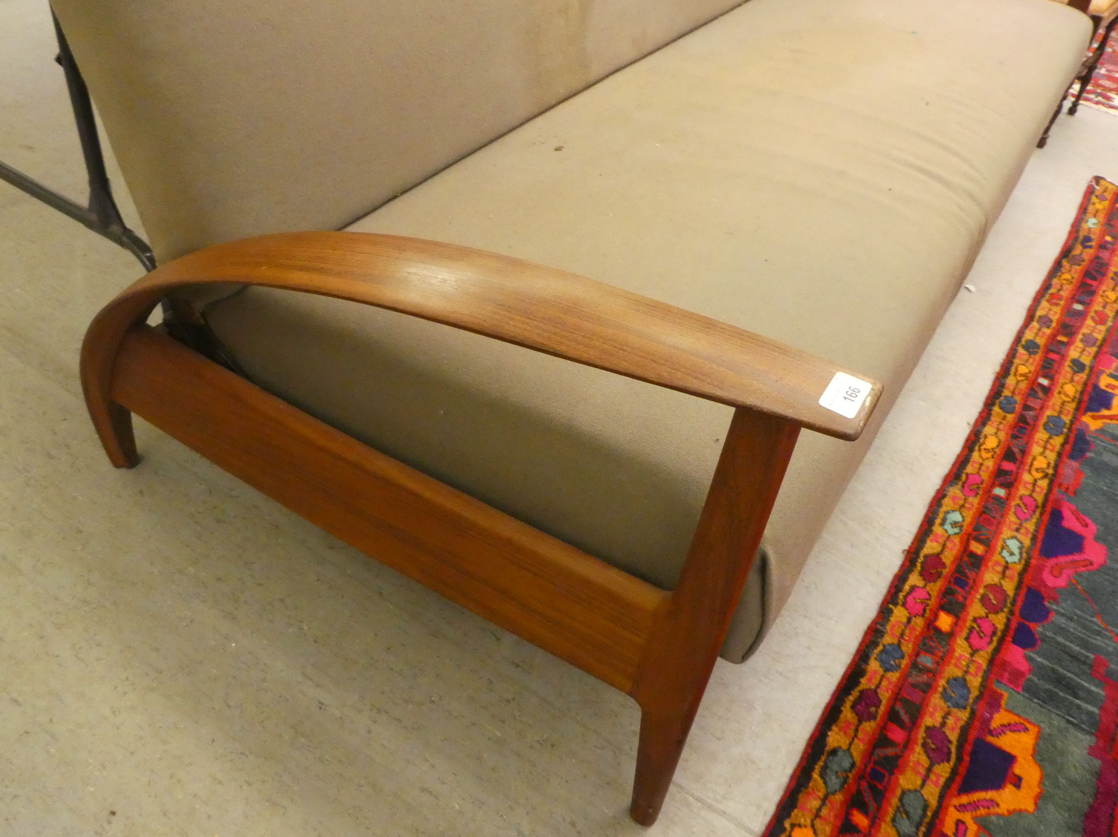 A 1970s teak framed bed settee, raised on a panelled underframe and turned legs   bears a - Image 3 of 5