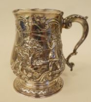 A George III silver mug of baluster form with a hollow, double C-scrolled handle, embossed and