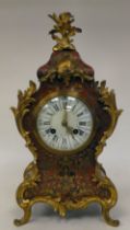 A late 19thC French red boulle cased mantel clock of waisted form with foliate scrolled gilt metal