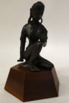 A 20thC cast and patinated bronze Asian female dancer, seated cross-legged, on a hardwood plinth