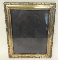 A silver and glazed photograph frame, decorated with ribbon tied ornament, on a fabric back  JB