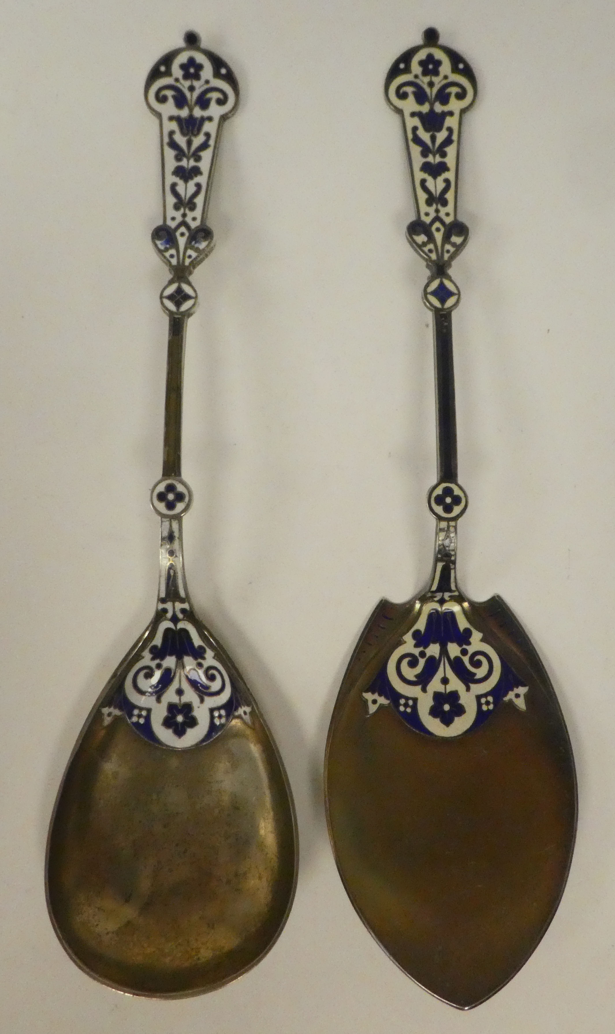 A Continental silver coloured metal and dark blue and white enamel serving spoon and slice