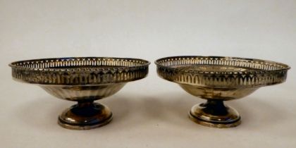 A pair of silver pedestal sweet dishes with radiating, facetted sides and pierced borders