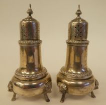 A pair of North American George III design Sterling silver pepper pots with cast and engraved