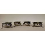 A set of four Edwardian silver salt cellars of ogee form with flared, foliate and shell cast rims,