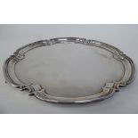 A Georgian style silver salver with a raised piecrust border, elevated on pad feet  Cooper Bros &