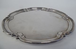 A Georgian style silver salver with a raised piecrust border, elevated on pad feet  Cooper Bros &