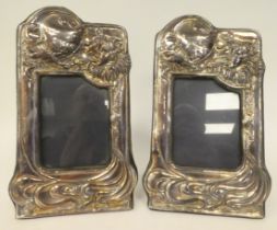 A pair of silver and glazed photograph frames, embossed in Art Nouveau inspired whiplash forms and