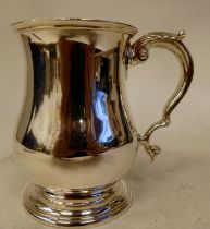 An Edwardian silver one pint mug of baluster form with an applied wire rim, stepped footrim and
