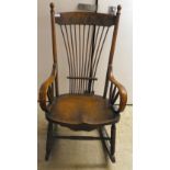 An early 20thC oak and beech bentwood framed, spindled open arm rocking chair