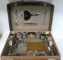 An early 20thC stitched pigskin covered and watered, satin lined vanity case, fully fitted with a