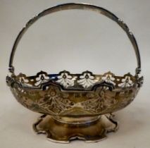 A silver basket with a decoratively pierced border and swing handle, on a splayed pedestal