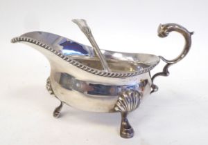 An Edwardian silver sauce boat with a gadrooned border and double S-scrolled handle, elevated on