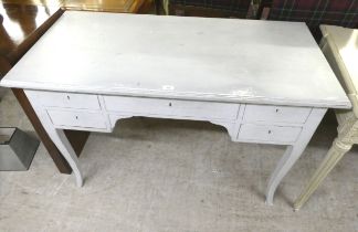 A modern pale blue painted and distressed desk with five drawers, raised on splayed legs  30"h  46"w