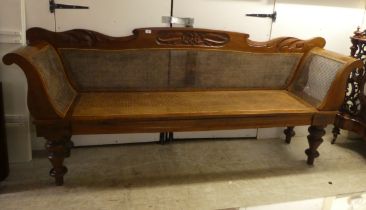 A modern Colonial design fruitwood framed, scroll end settee with a caned back and seat, raised on