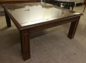 A modern oak coffee/centre table with a carved frieze, raised on block legs  20"h  47"w