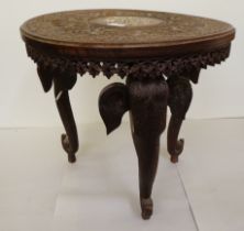 An Indian carved teak side table with an inlaid bone central motif, raised on elephants' head