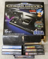 A Sega Mega Drive games console with power pack, two controllers and seven games