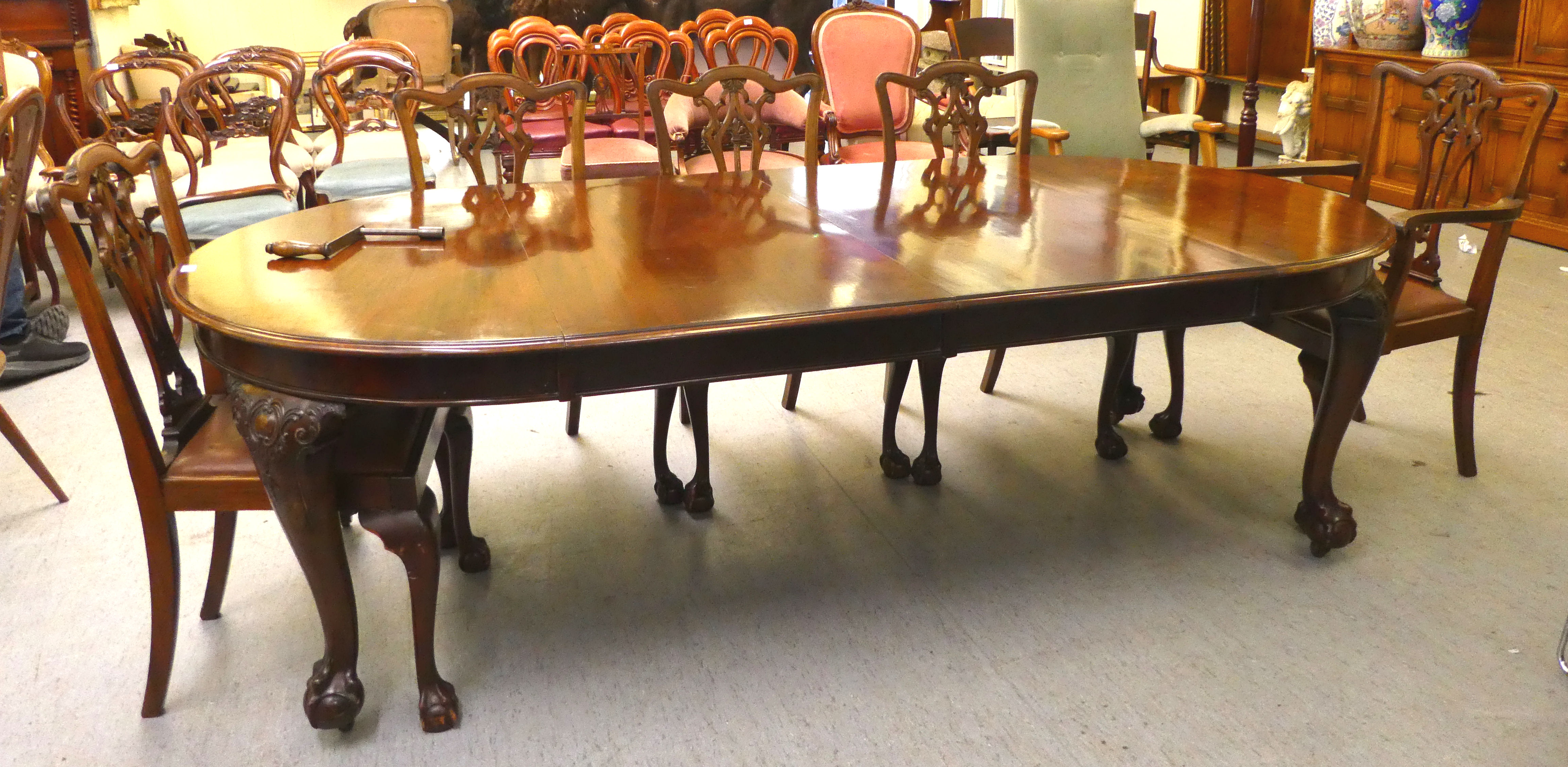 A 1920s mahogany wind-out dining table, raised on cabriole legs, talon and ball feet  29"h  46"L