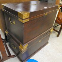 Two modern fruitwood military design chests, each with a hinged lid and brass capped corners, on a