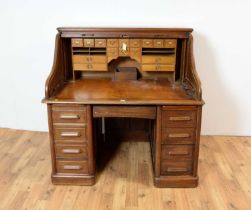 An early 20th Century roll-top pedestal desk