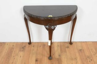 A Georgian style carved mahogany demi lune card table