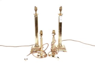 A pair of brass Corinthian column table lamps, smaller brass lamps, and lampshades