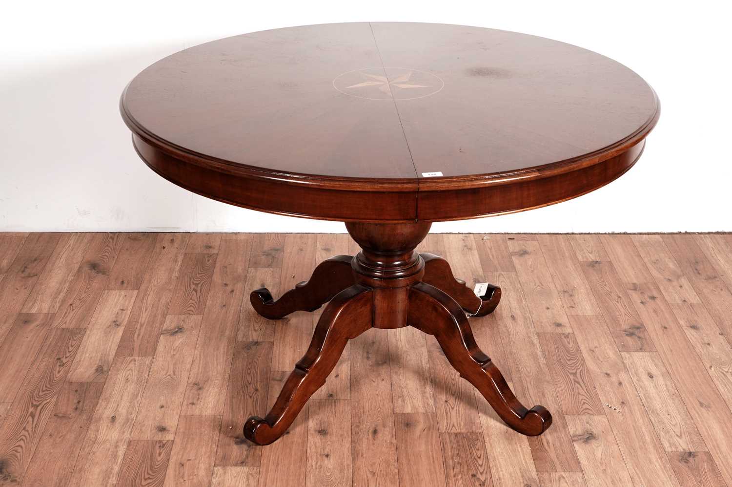 A mahogany and satinwood inlaid circular extending dining table