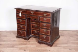 A George III mahogany and satinwood banded kneehole desk