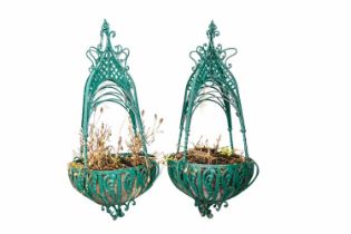 A pair of green painted cast metal wall hanging planters