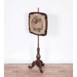 A Victorian carved mahogany needlework pole screen