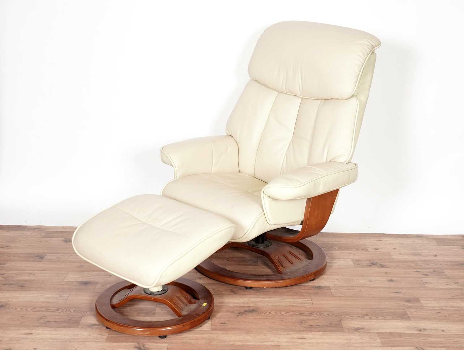 A leather reclining armchair with matching footstool by Global Furniture Alliance